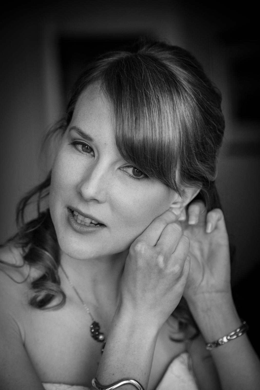 Bride putting on earrings